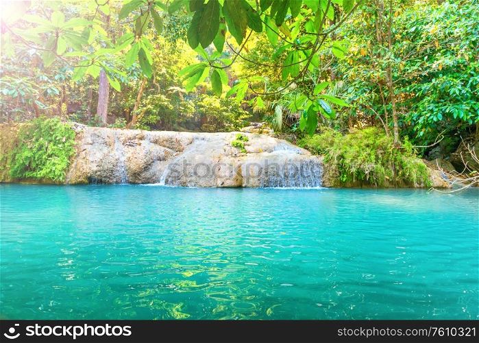 Tropical landscape with beautiful waterfall and emerald lake in green wild jungle forest. Erawan National park, Kanchanaburi, Thailand