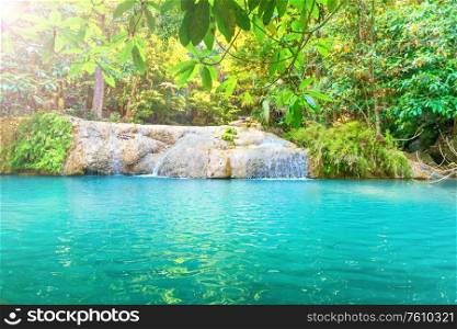Tropical landscape with beautiful waterfall and emerald lake in green wild jungle forest. Erawan National park, Kanchanaburi, Thailand