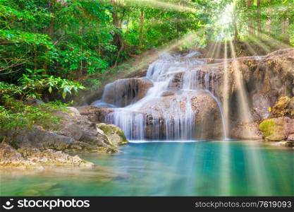 Tropical landscape with beautiful waterfall, wild rainforest with green foliage and flowing water. Erawan National park, Kanchanaburi, Thailand