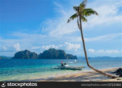 Tropical landscape with mountain islands, palm tree and lonely boat