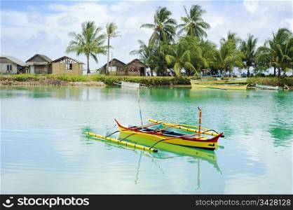 Tropical landscape with traditional Philippines boats and village on Calicoan island, Philippines