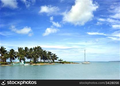 Tropical landscape with traditional Philippines boats and yacht on Calicoan island, Philippines