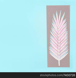 Tropical palm leaves on pastel blue background, top view, flat lay. Creative botanical layout. Copy space