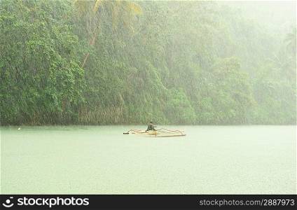 Tropical rain above river running through rainforest