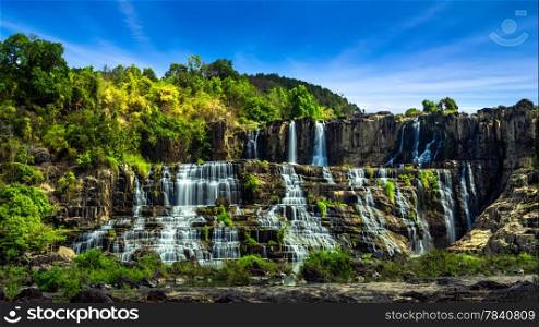 Tropical rainforest landscape panorama with flowing Pongour waterfall under blue sky. Da Lat, Vietnam