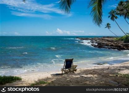 Tropical rocky beach with coconut palm trees, sandy beach and ocean. Tangalle, Southern Province, Sri Lanka, Asia.