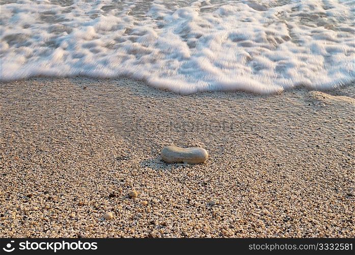 Tropical sand beach with stone and sea waves