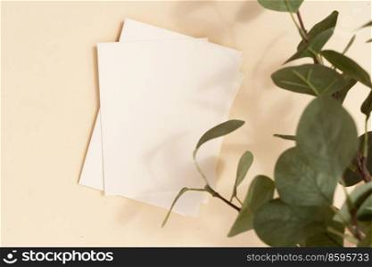 Tropical summer stationery mock-up scene. Blank business card, green eucaliptus leaves, beige textured table background. Flat lay, top view. summer stationery mock-up scene.