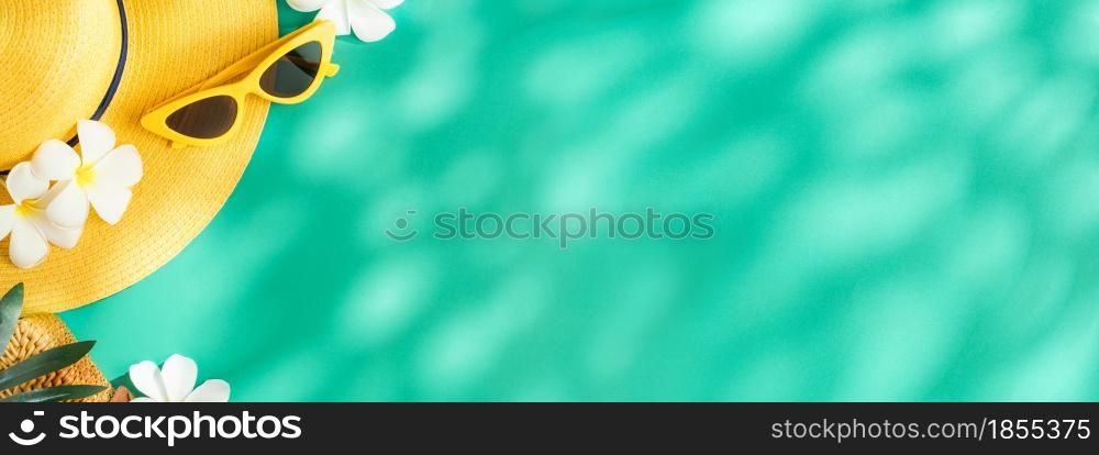 Tropical summer yellow straw hat and singleness on turquoise background with sunlight and shade.banner mockup space for product display advertise