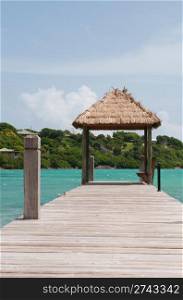 tropical wooden jetty with hut over sea in Long Bay, Antigua