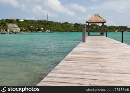 tropical wooden jetty with hut over sea in Long Bay, Antigua