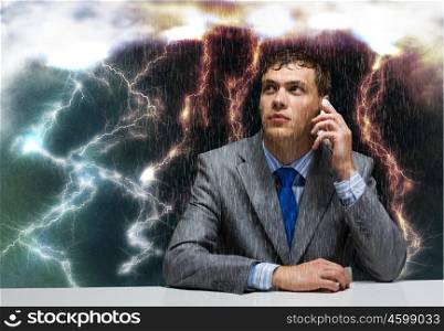 Troubles in business. Young troubled wet businessman talking on phone