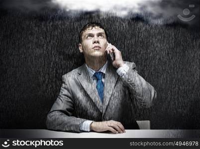 Troubles in business. Young troubled wet businessman talking on phone