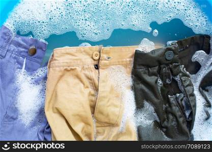 Trousers soak in powder detergent water dissolution, washing cloth. Laundry concept