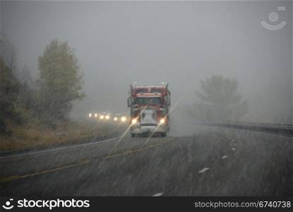 Truck and other vehicles moving through fog and snowstorm, Rocky Mountains, Idaho
