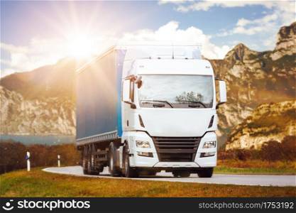 Truck drive on asphalt road in rural italian landscape at sunset
