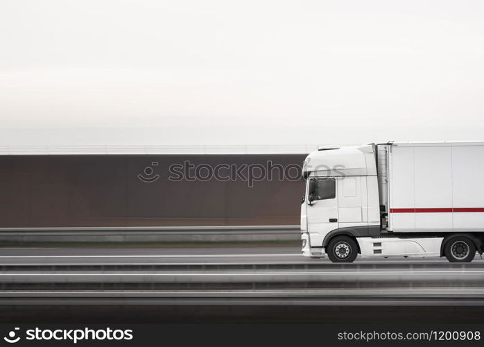 Truck vehicle moving fast on the highway, near Stuttgart, Germany. Selective focus logistic vehicle. White truck in motion. Freight transport vehicle