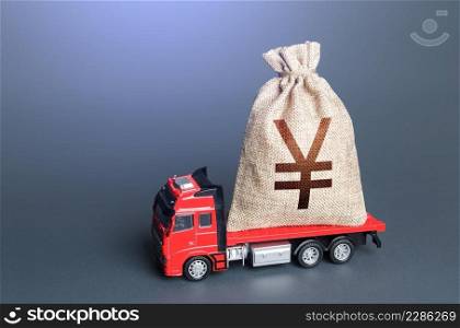 Truck with a chinese yuan or japanese yen money bag. Loan or deposit. High super income. Payment of taxes. Debt load. Money transfers and transactions. Financial aid, investments and subsidies.