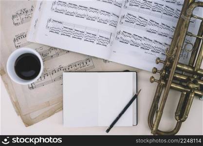 trumpet sheet music near drink notepad