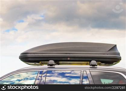 Trunk or cargo box on the roof of the car. Travel, family vacation. Accessories for transportation.. Trunk box fixed at roof top of the car