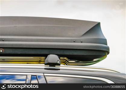 Trunk or cargo box on the roof of the car. Travel, family vacation. Accessories for transportation.. Trunk box fixed at roof top of the car