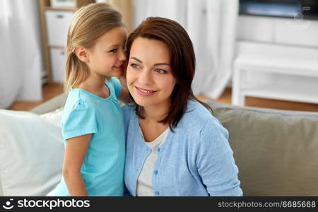 trust, gossiping and family concept - daughter whispering secret to mother at home. daughter whispering secret to mother at home