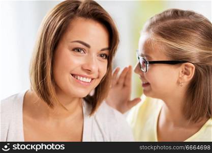 trust, gossiping and family concept - happy daughter whispering secret to her mother. happy daughter whispering secret to her mother