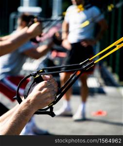 trx training outdoors focus on strong male hands