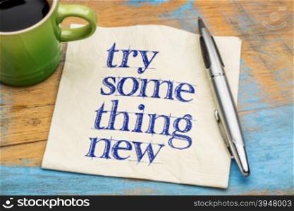 Try something new advice or reminder - handwriting on a napkin with a cup of coffee