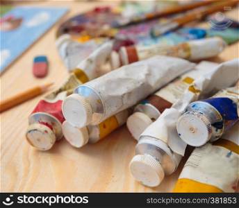 tubes of paint on a wooden table