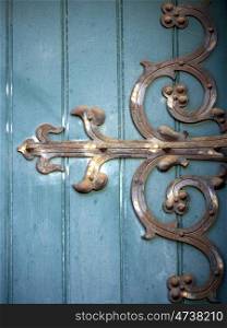 Tuerband-an-tuerkiser-Tuer. rusty hinge of metal on turquoise door