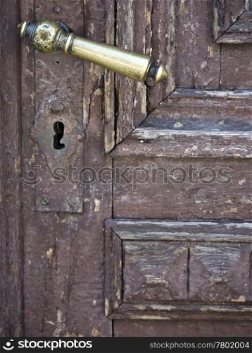 Tuerklinke-goldfarben. golden door handle in an old door