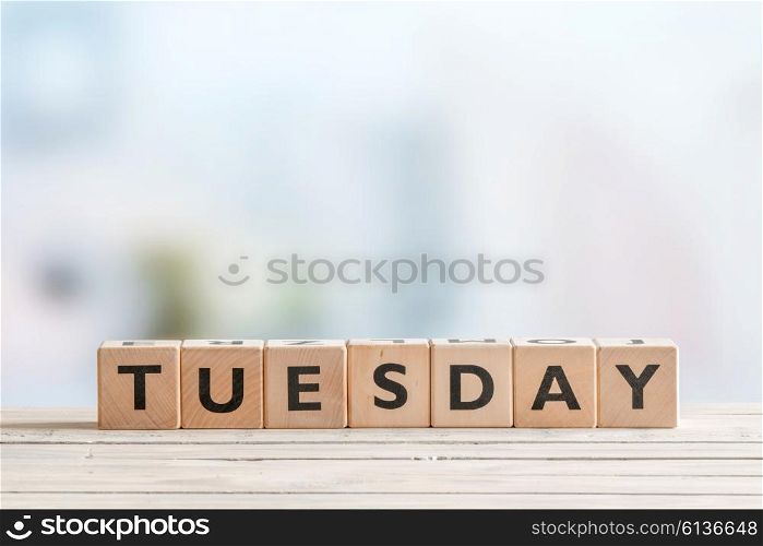 Tuesday sign on a wooden table in bright colors