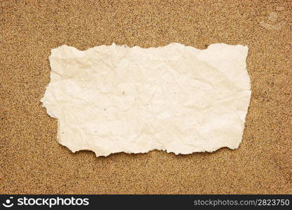 tuft of old torn paper on a sandy beach