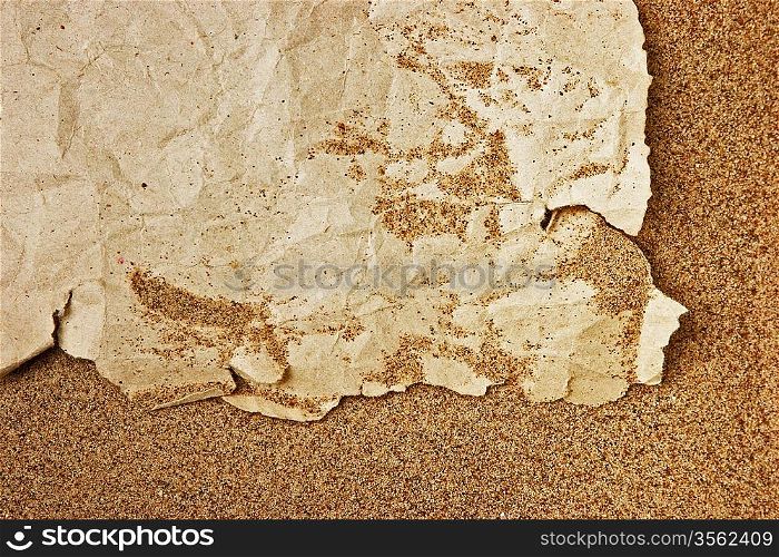 tuft of old torn paper on a sandy beach