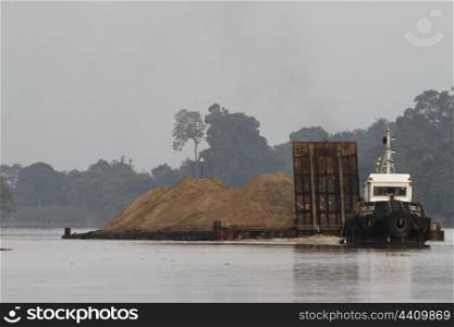 Tug boat pulling sand dredged from Kinabatangan river