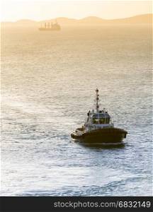 Tugboat in sunset light returning to harbor