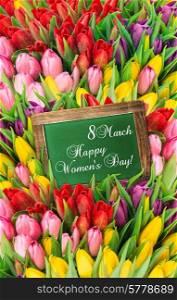 tulips and blackboard. fresh spring flowers with water drops. womens day background with sample text Happy Women&rsquo;s Day!