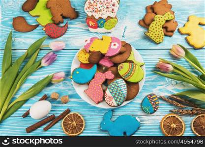 Tulips and gingerbread cookies. Tulips and gingerbread cookies on darken concrete background for Easter.