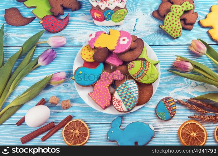 Tulips and gingerbread cookies. Tulips and gingerbread cookies on white and blue wooden background for Easter.