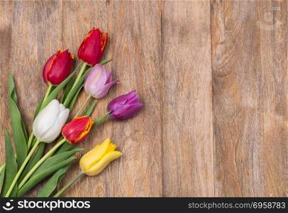 tulips bouquet on wooden planks background, copy space, top view. tulips on wooden background