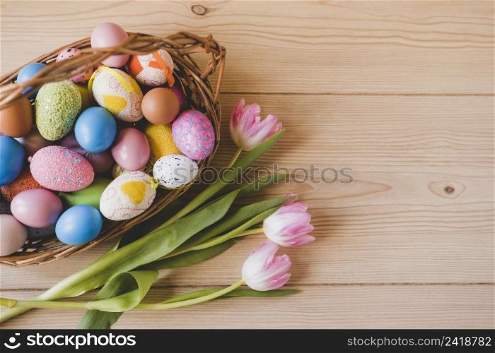 tulips near basket with easter eggs