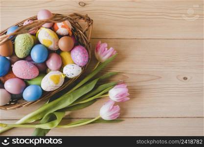 tulips near basket with easter eggs
