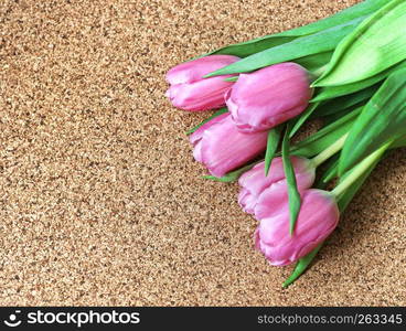 Tulips on dark brown surface. Bouquet of tulips close-up. Congratulations for the holiday.