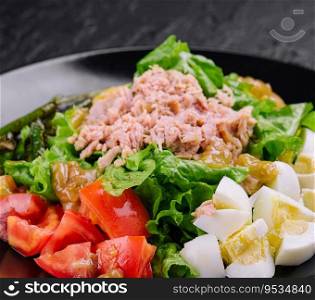 Tuna and vegetable salad on black plate