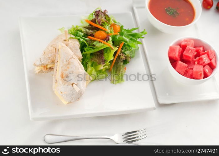 tuna fish and cheese sandwich with fresh mixed salad ,watermelon and gazpacho soup on side,with fresh vegetables on background ,MORE DELICIOUS FOOD ON PORTFOLIO