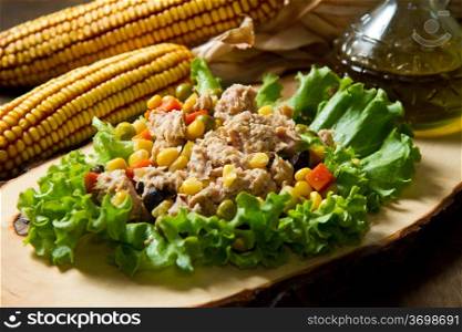 tuna salad with mais and cob on wood board