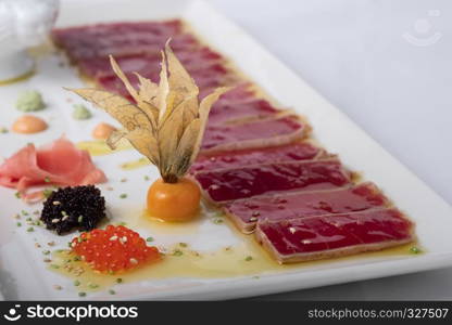 tuna tataki on olive oil background accompanied by caviar