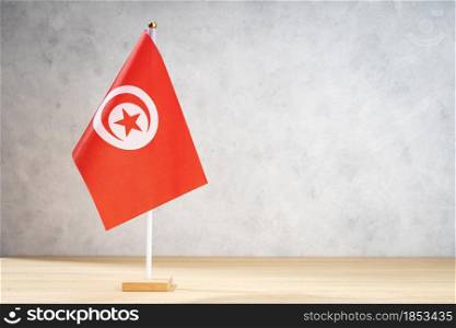 Tunisia table flag on white textured wall. Copy space for text, designs or drawings