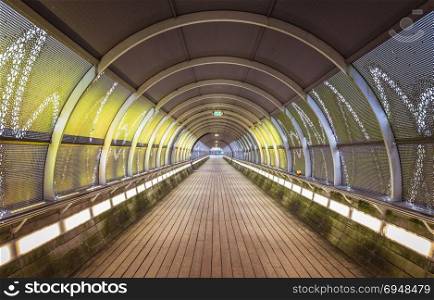 tunnel with yellow lights and mosaic at the end of the tunnel. tunnel with lights in yellow and grey